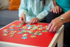 Close up shot of child and adult hands working on a puzzle
